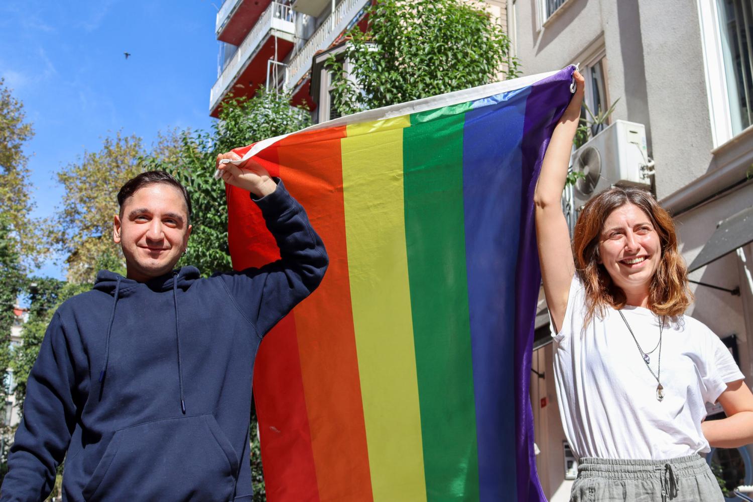 https://cdn.noron.vn/2023/01/02/two-people-carrying-rainbow-flag-down-street-1672594566.jpg